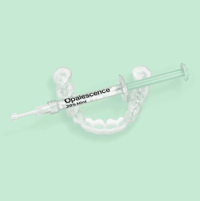 Opalescence take-home teeth whitening gel syringe with clear dental trays on a mint green background.